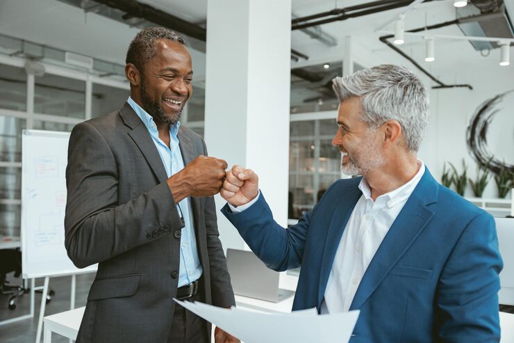 Two colleagues shaking hands after closing a sales deal